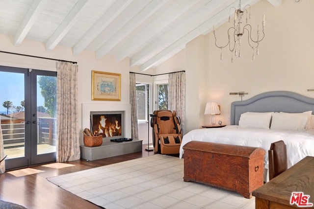 bedroom featuring access to outside, a chandelier, french doors, light wood-type flooring, and vaulted ceiling with beams