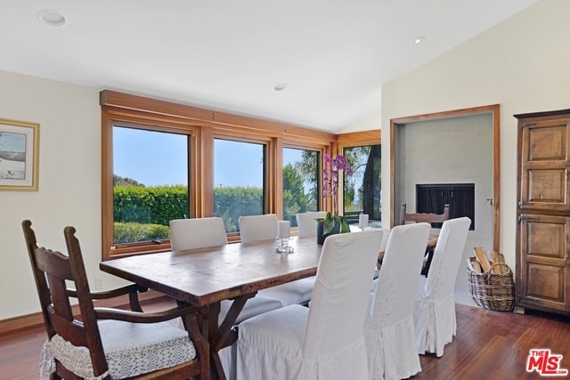 dining room with dark wood-type flooring and lofted ceiling