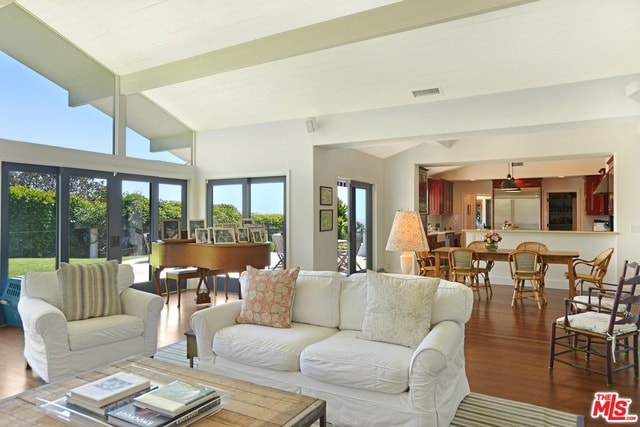 living room with vaulted ceiling, hardwood / wood-style flooring, and french doors