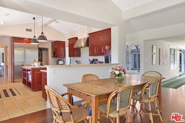 dining area with lofted ceiling with beams and light tile patterned floors