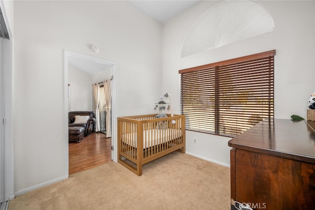 carpeted bedroom featuring a nursery area