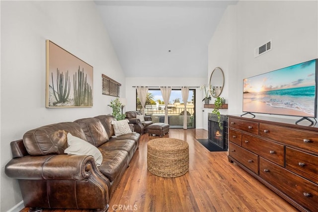 living room featuring light hardwood / wood-style flooring and high vaulted ceiling