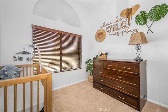 bedroom featuring a crib and light carpet