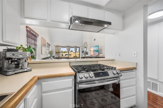 kitchen featuring stainless steel gas stove, tile patterned floors, and white cabinetry