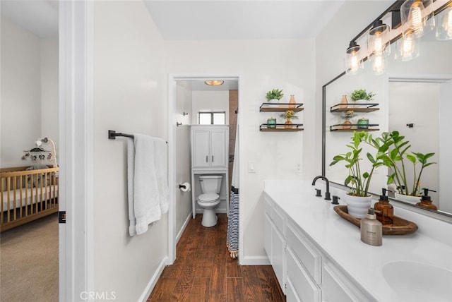 bathroom with toilet, wood-type flooring, and vanity