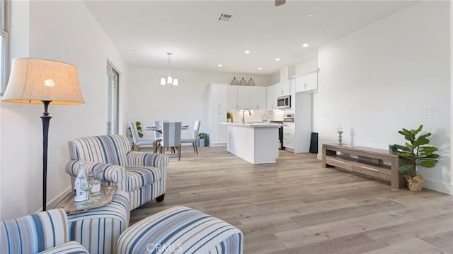 living room with sink and light hardwood / wood-style floors