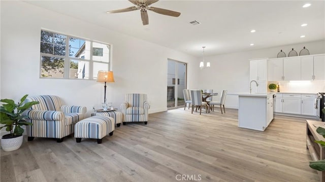 living room with light wood-type flooring and ceiling fan