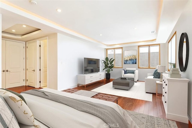 bedroom with a raised ceiling and hardwood / wood-style flooring