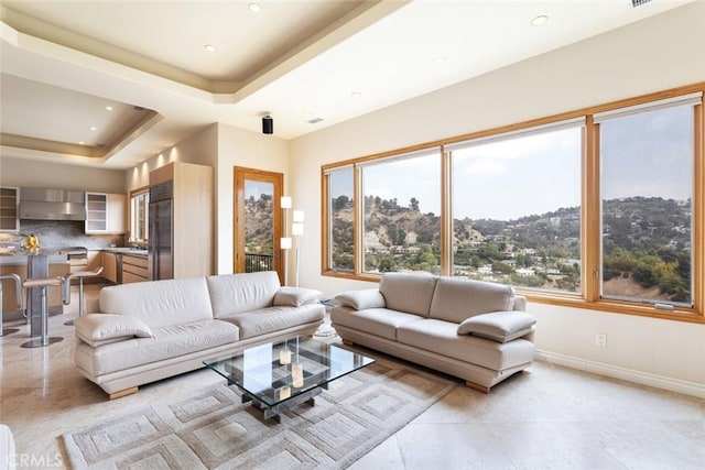 tiled living room featuring a raised ceiling