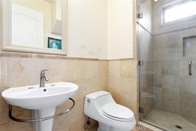 bathroom with tile walls, a shower with door, and toilet