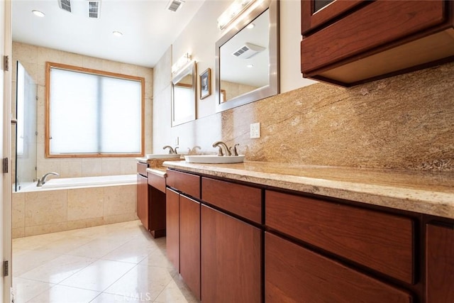 bathroom with tiled bath, tile patterned floors, and vanity