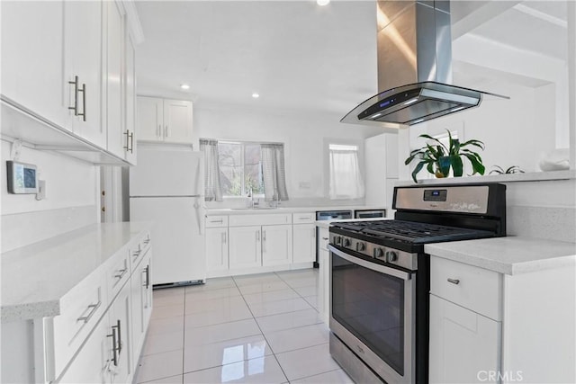 kitchen with white cabinets, island exhaust hood, white fridge, and stainless steel gas range oven