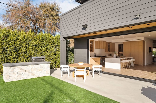 rear view of property with a lawn, outdoor dry bar, and area for grilling