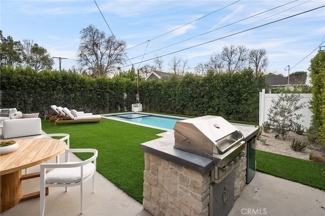view of swimming pool with a patio area, a lawn, a fenced backyard, a fenced in pool, and an outdoor kitchen