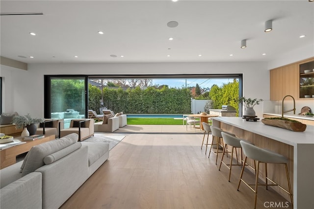 living area with light wood-style floors and recessed lighting
