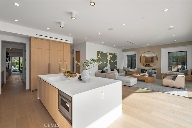 kitchen with recessed lighting, light wood-style flooring, modern cabinets, and a sink