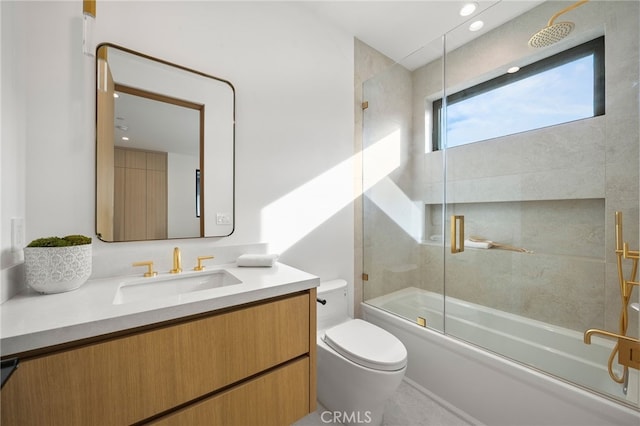 bathroom featuring toilet, vanity, and bath / shower combo with glass door