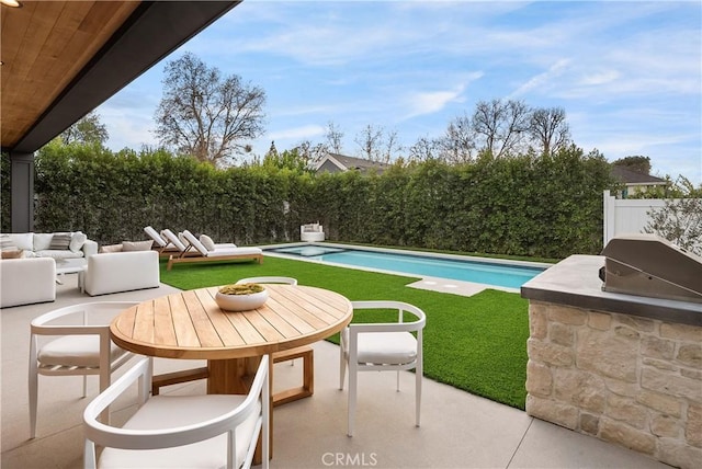 view of pool with a patio area, outdoor lounge area, a fenced backyard, and a lawn