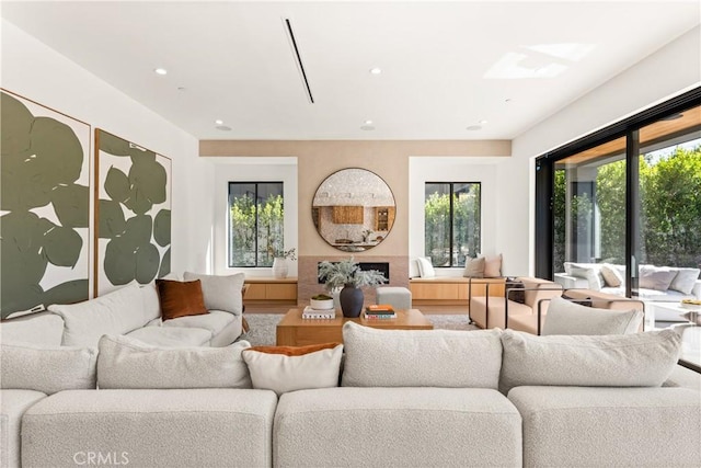 living area with recessed lighting, plenty of natural light, and a fireplace