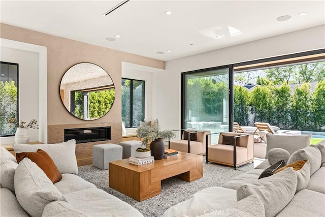 living area featuring recessed lighting and a glass covered fireplace