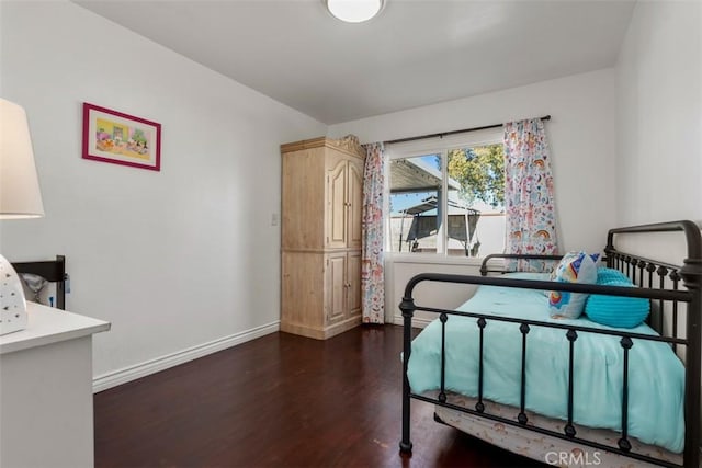 bedroom with dark hardwood / wood-style floors