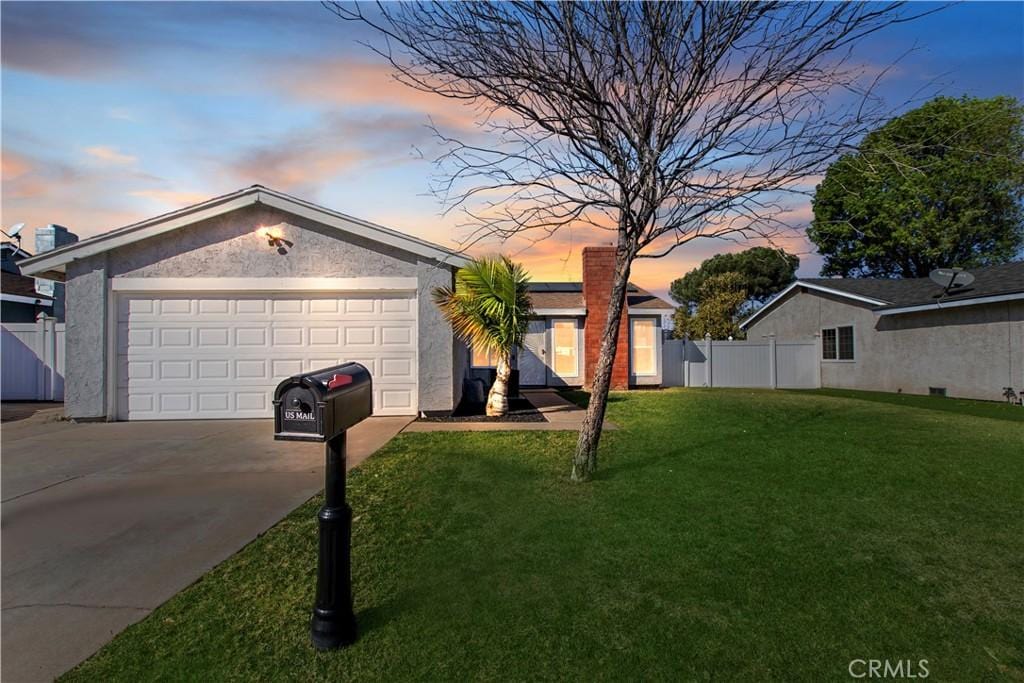 ranch-style home with a garage and a lawn