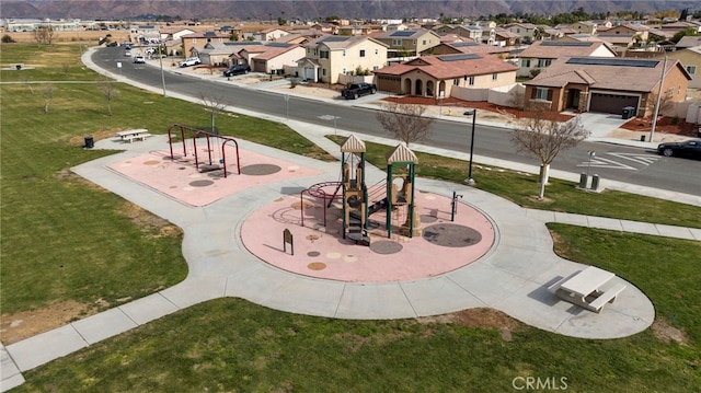 view of home's community featuring a playground and a yard