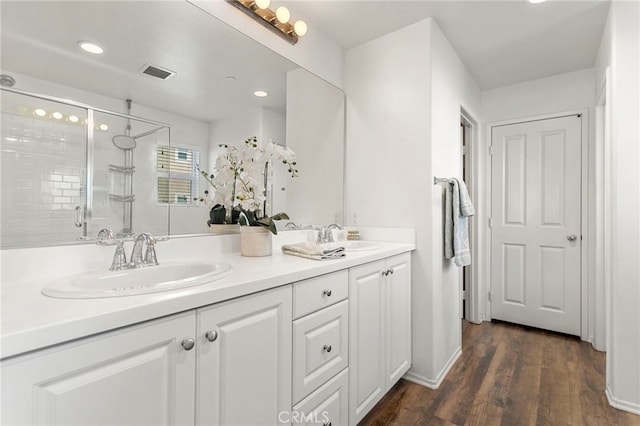 bathroom featuring hardwood / wood-style flooring, vanity, and a shower with door