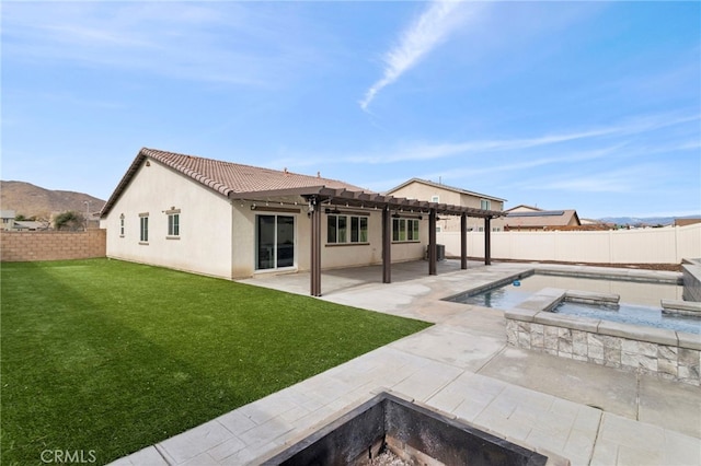 back of house with a lawn, a pergola, a patio area, a pool with hot tub, and a mountain view