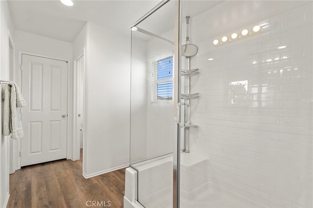 bathroom with wood-type flooring and a shower with shower door