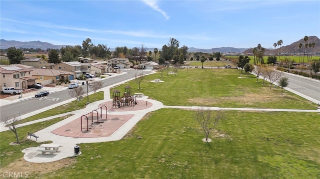 surrounding community with a mountain view and a playground