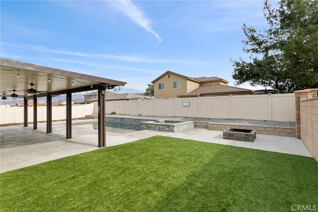 view of yard with a swimming pool with hot tub, a patio area, ceiling fan, and an outdoor fire pit