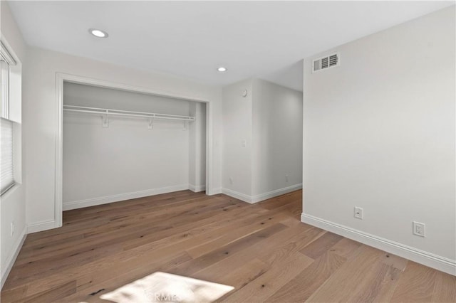 unfurnished bedroom with wood-type flooring and a closet