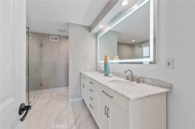 bathroom featuring an enclosed shower and vanity