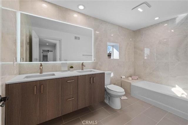 bathroom with toilet, tile patterned flooring, tile walls, and vanity