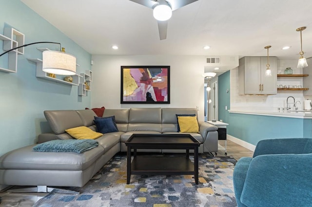 living room with ceiling fan and dark wood-type flooring