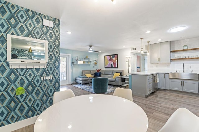 dining area with sink, ceiling fan, and light hardwood / wood-style flooring