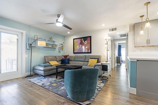 living room with ceiling fan and light wood-type flooring