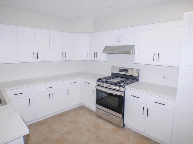 kitchen with light tile patterned flooring, stainless steel range with gas cooktop, and white cabinetry