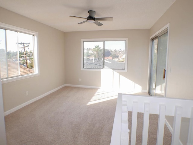 empty room with ceiling fan and light colored carpet