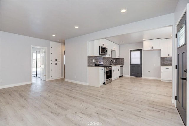 kitchen featuring white cabinetry, a healthy amount of sunlight, appliances with stainless steel finishes, and tasteful backsplash