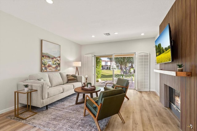 living room with wooden walls and light hardwood / wood-style flooring