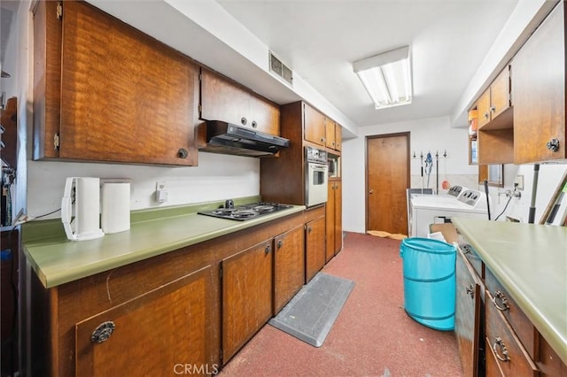 kitchen with white oven, washer and clothes dryer, and stainless steel gas cooktop