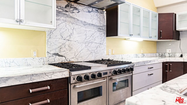 kitchen with range with two ovens, white cabinetry, dark brown cabinets, and range hood