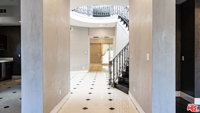 foyer with a towering ceiling and light tile patterned floors