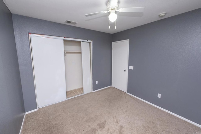 unfurnished bedroom featuring light carpet, a closet, and ceiling fan