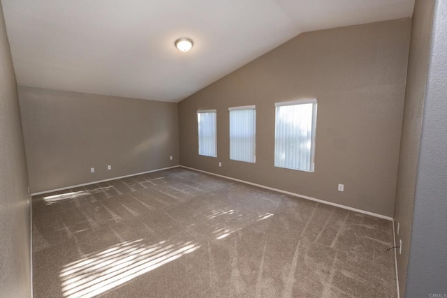 spare room with vaulted ceiling and dark carpet