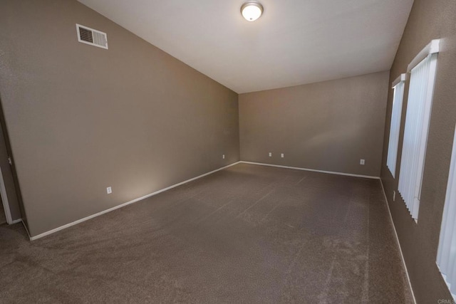 carpeted spare room featuring lofted ceiling