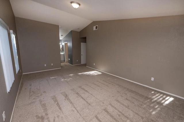 empty room featuring light carpet and vaulted ceiling