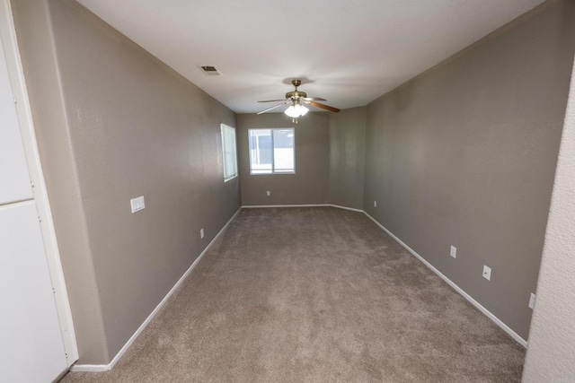 spare room with ceiling fan and carpet